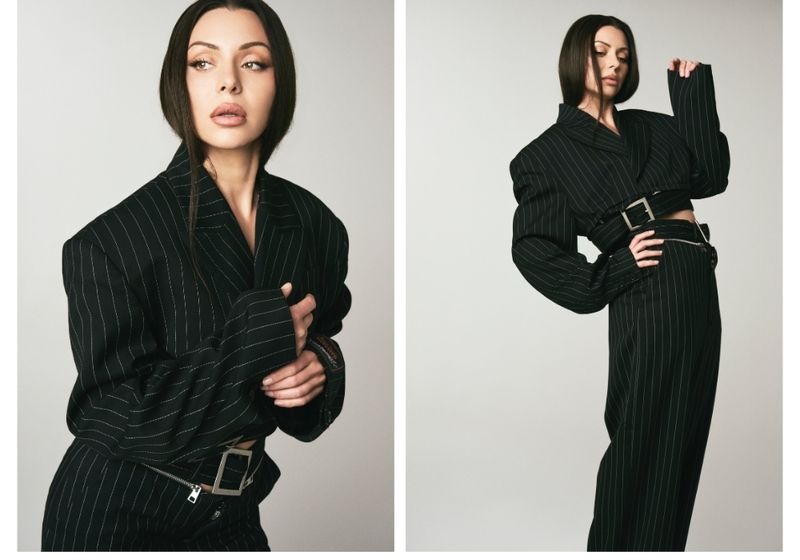 Side-by-side studio portraits of actress Neraida Bega wearing a black pinstripe suit, featuring a close-up beauty look and a full-body pose, highlighting her sleek hair and natural makeup