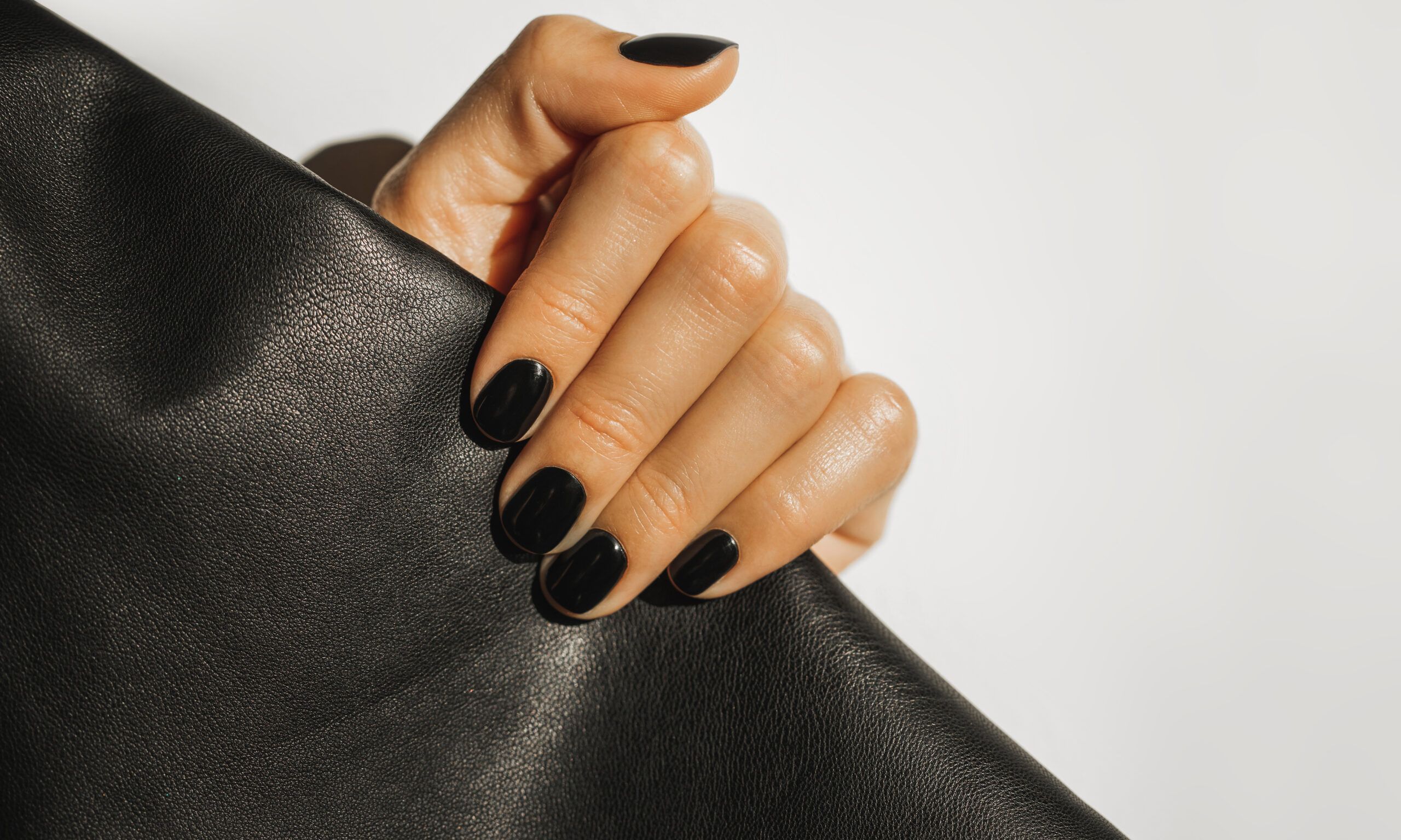 hand with black nails holding clutch