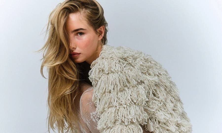woman with blonde wavy hair wearing a shaggy coat