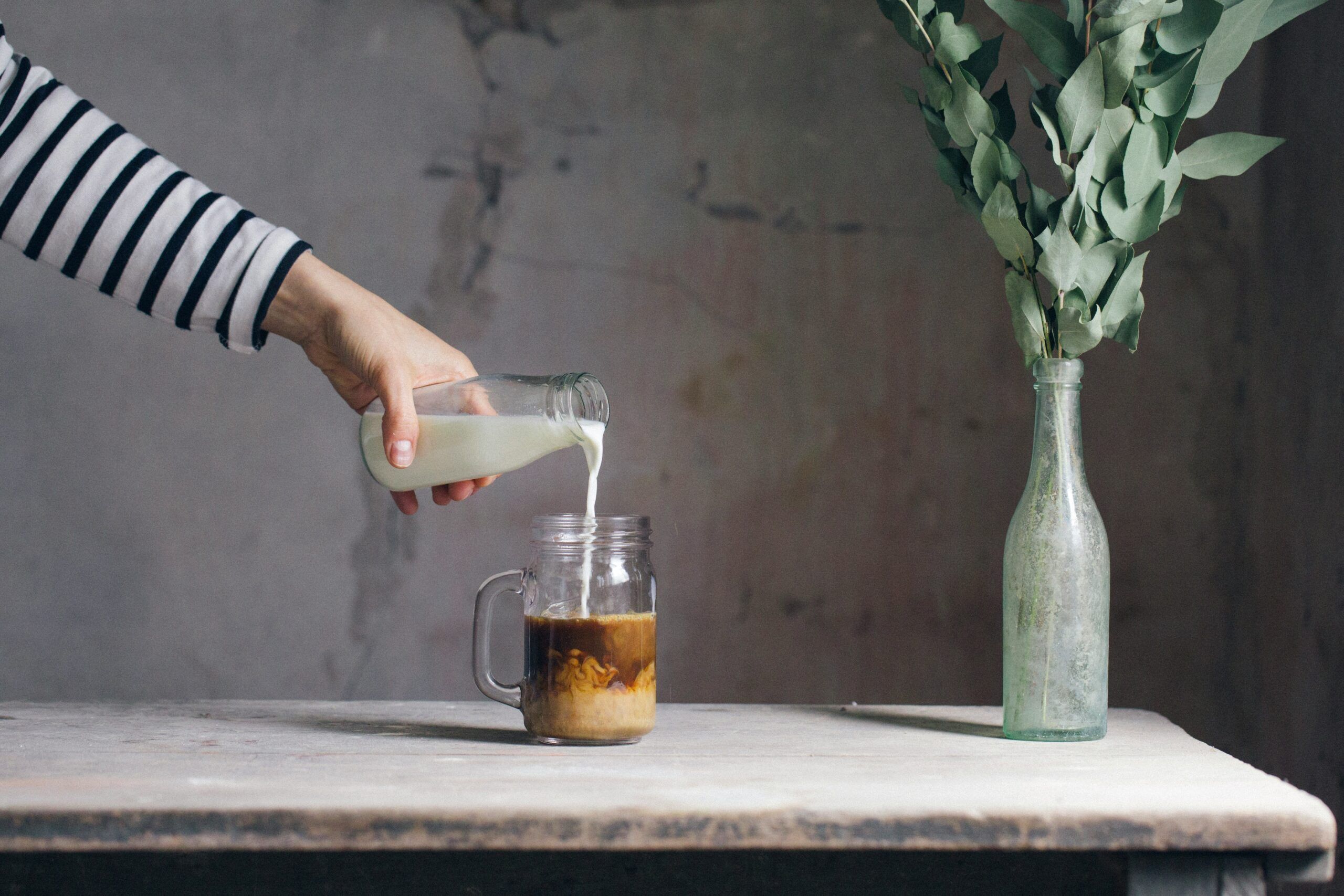 woman pouring milk and coffee