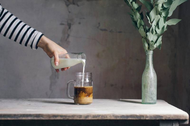 woman pouring milk and coffee