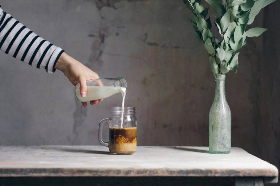 woman pouring milk and coffee