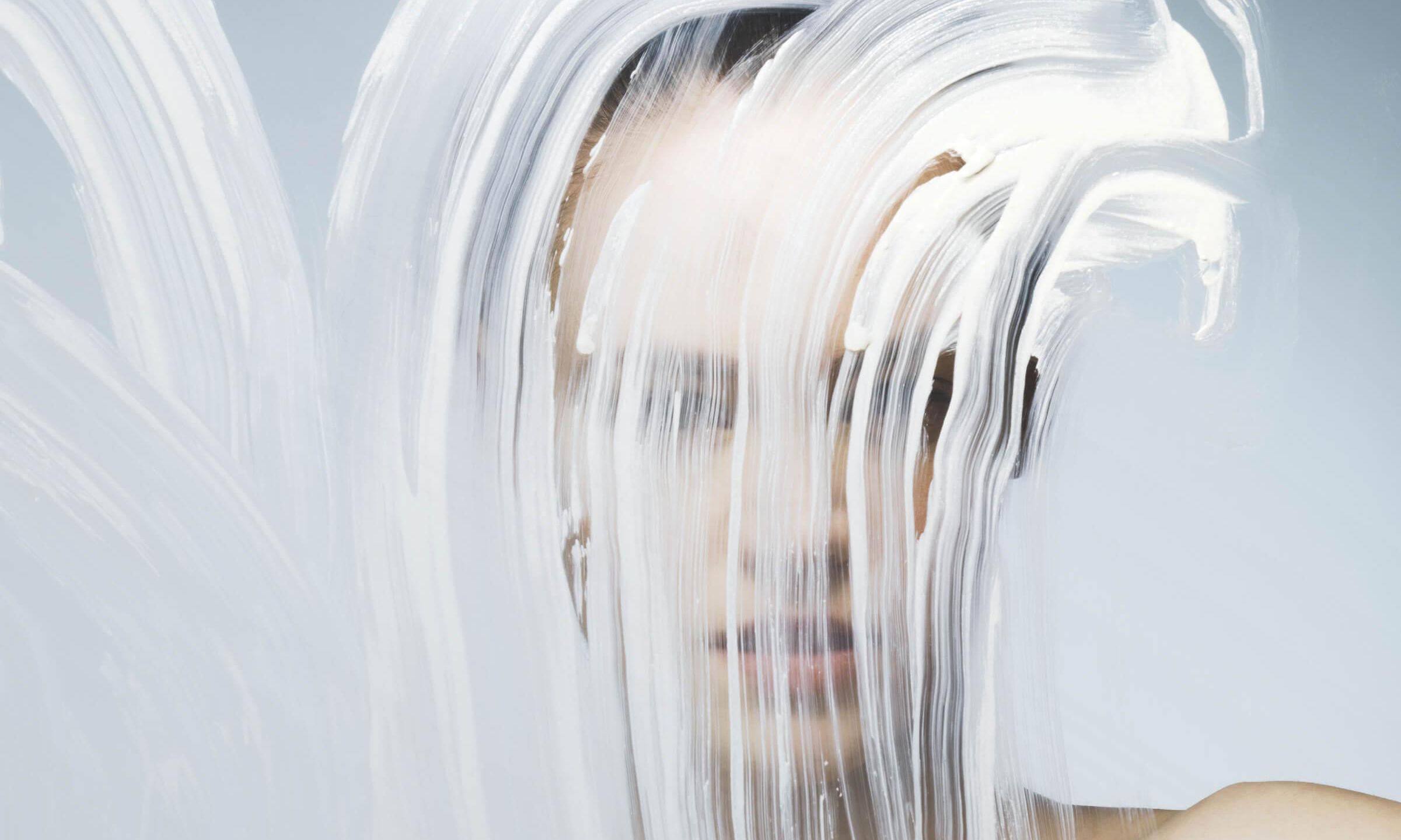 woman standing before a smeared glass