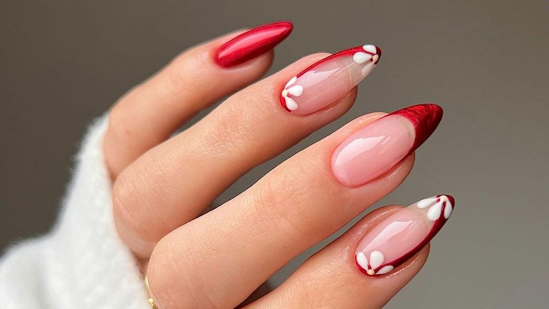 a close-up of red nails with floral design