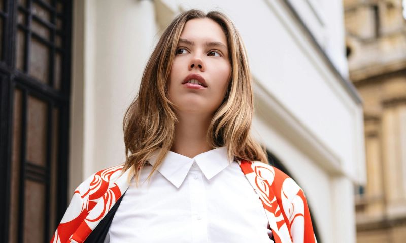 blonde woman in white blouse and red and white jacket