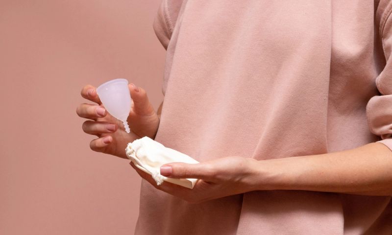 woman holding a menstrual cup