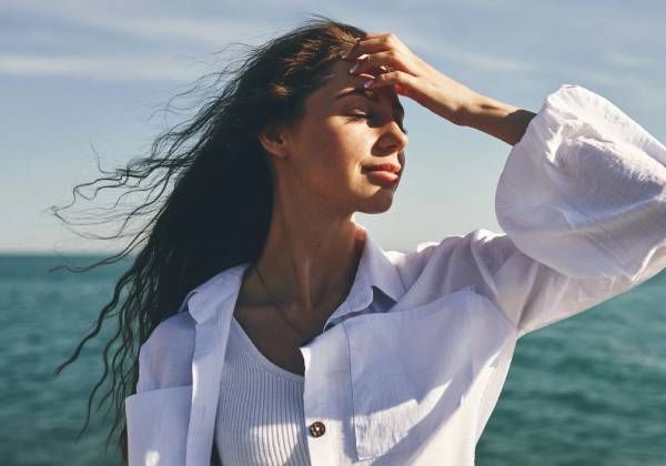 woman standing by the sea with air-dried hair