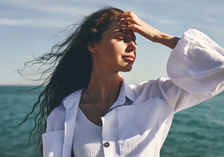 woman standing by the sea with air-dried hair