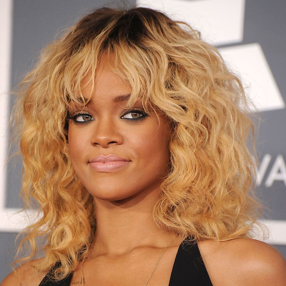 Rihanna with curly blonde hair and bangs