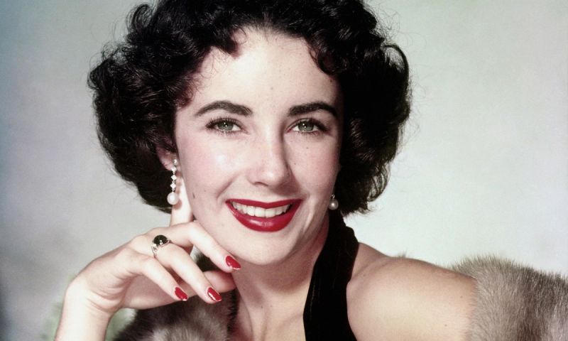 British-born American actress Elizabeth Taylor (1932 - 2011) in a fur stole, circa 1955.