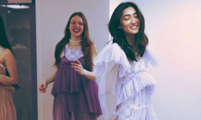 two fashionable woman in purple dresses