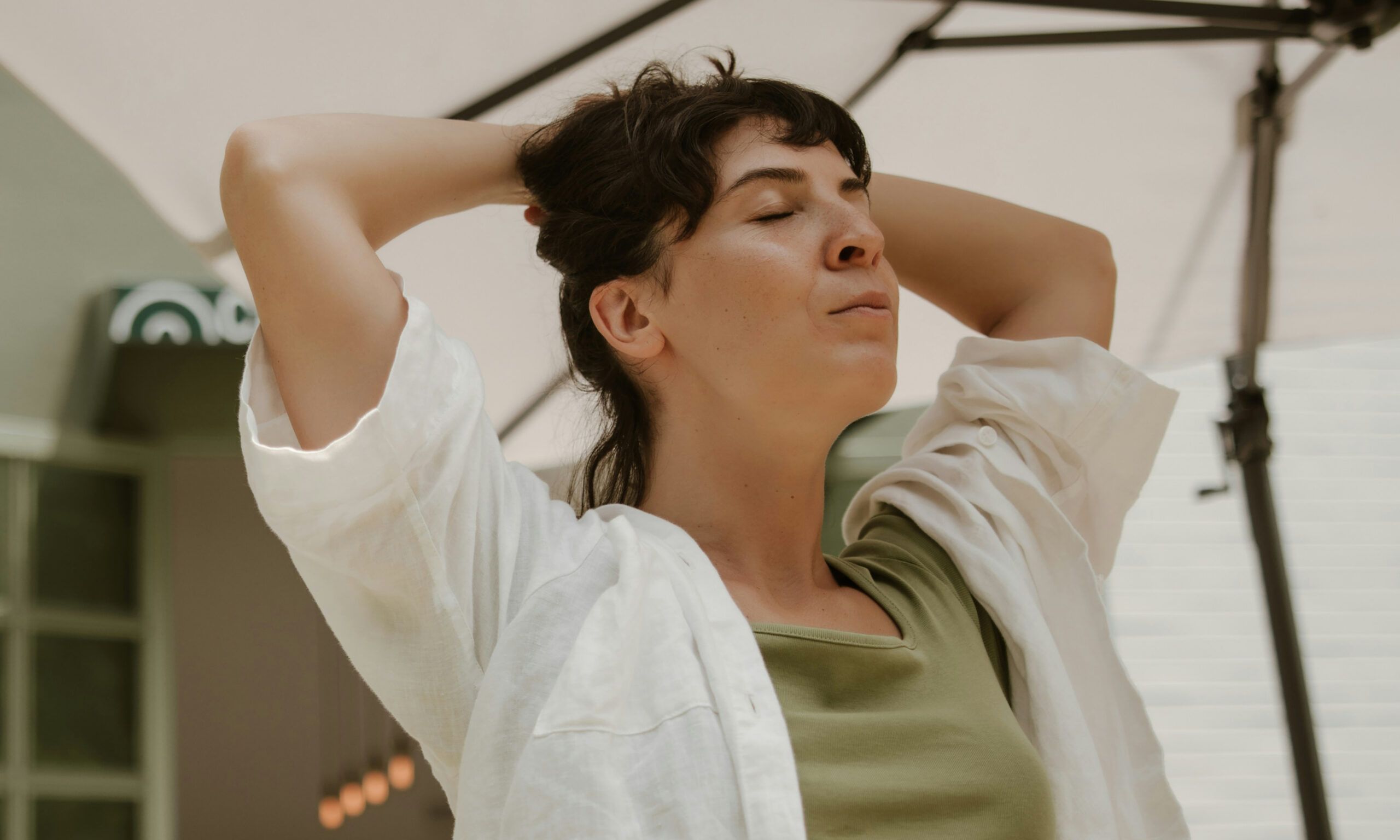 woman with hands in hair with eyes closed