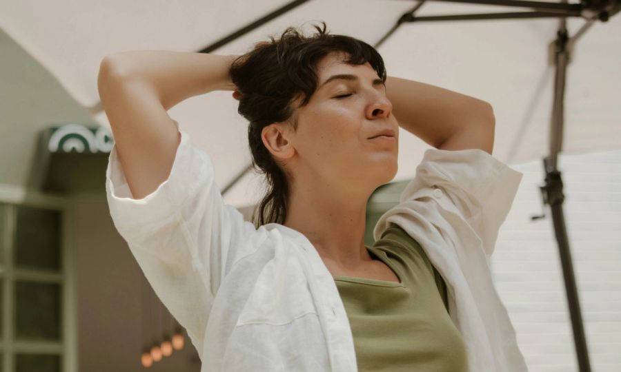 woman with hands in hair with eyes closed