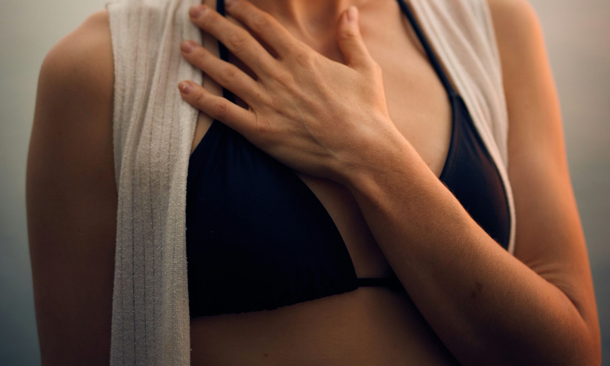 woman holding hand and arm over chest