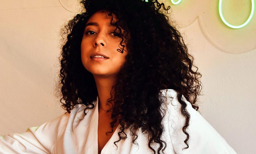 curly-haired woman in a white blouse