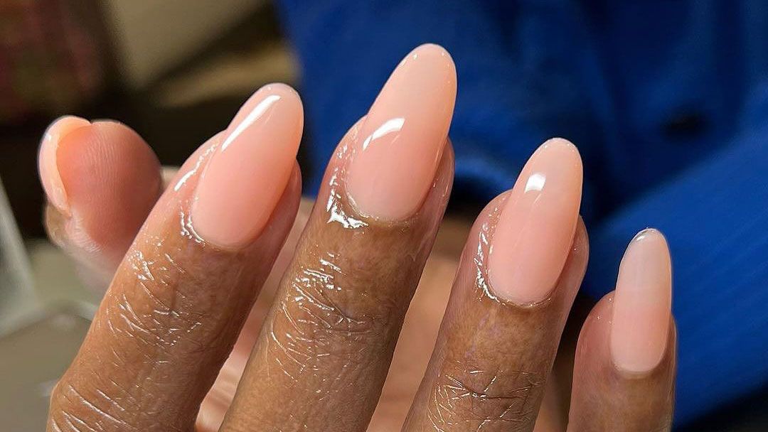 close-up of a manicure with oval-shaped nails and nude polish