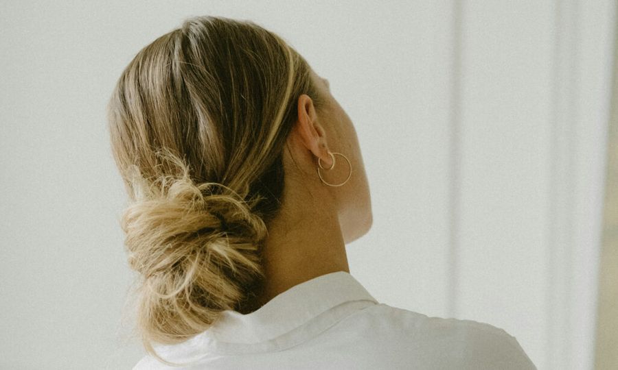 back view of woman with blonde hair in low bun