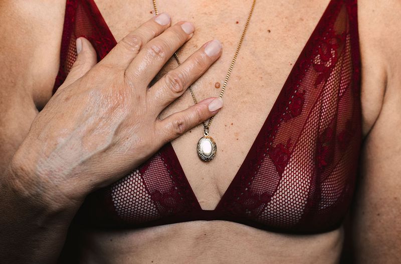 Woman wearing burgundy bran with hand on chest