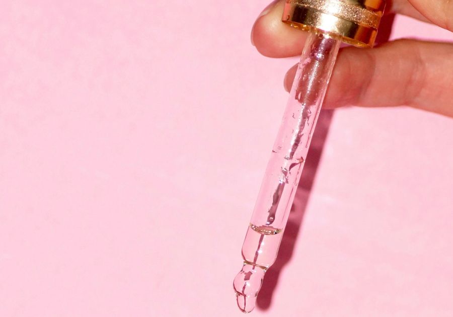 skin care dropper on pink background