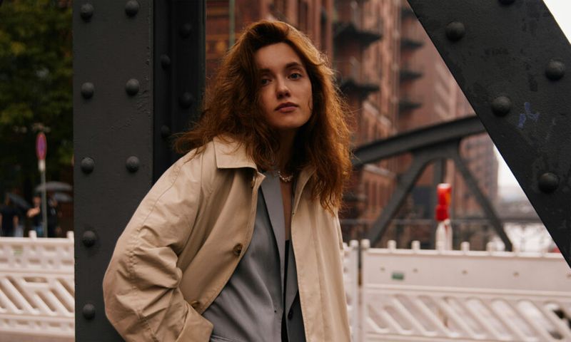 woman standing outdoors in trenchcoat