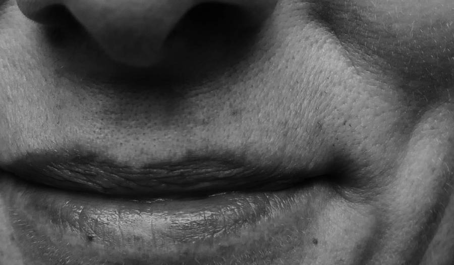 Black-and-white close-up of mature lips with fine lines and visible skin texture.