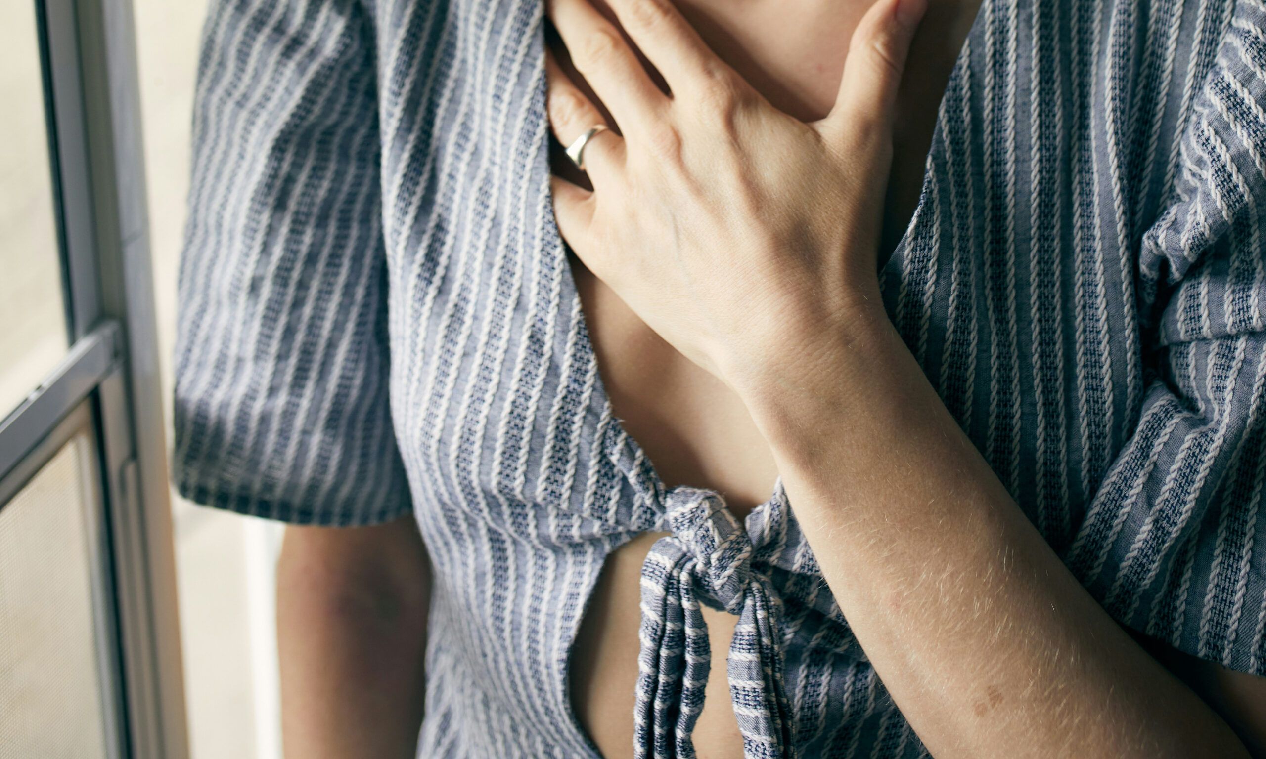 zoomed in image of woman with hand on her chest