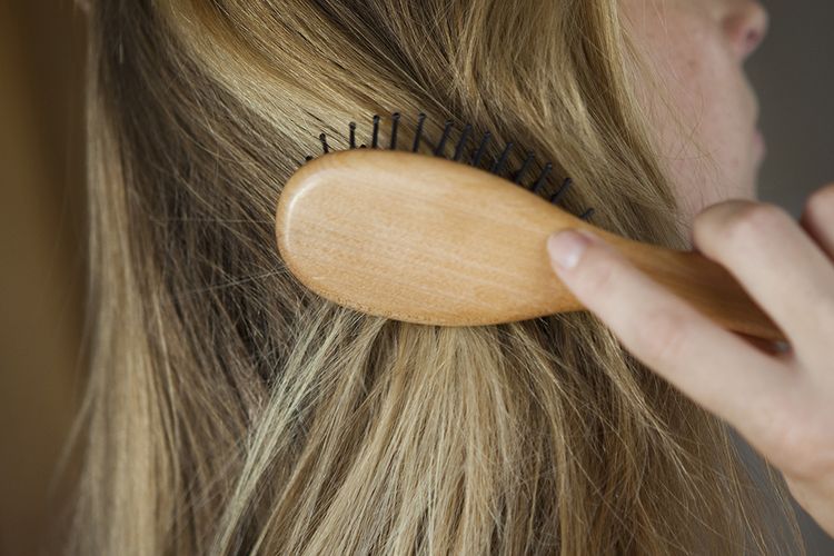 woman brushing blonde hair