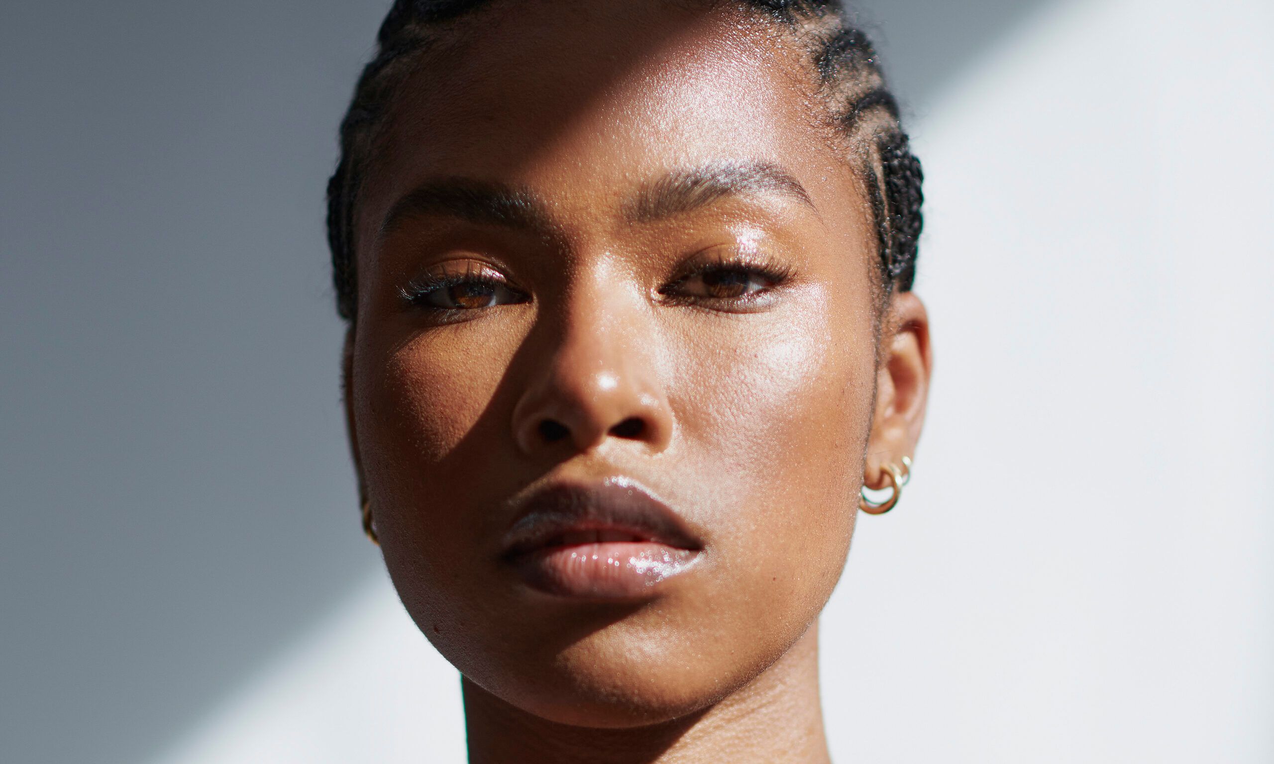 Front view of a black woman embracing her natural self in a portrait shot against a white background.