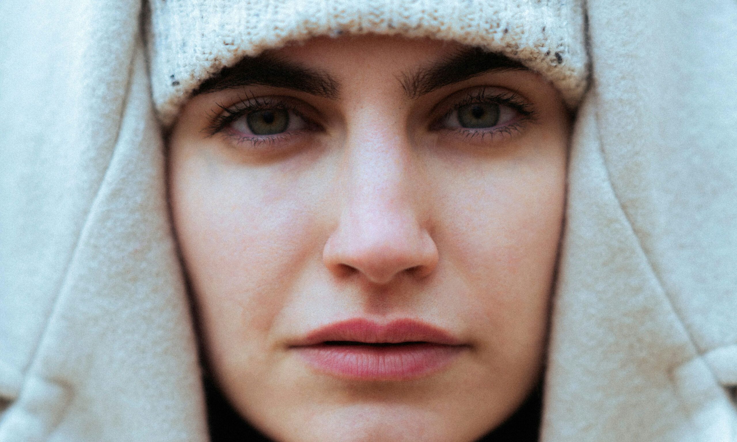 close up of woman's face who is wearing a winter hat