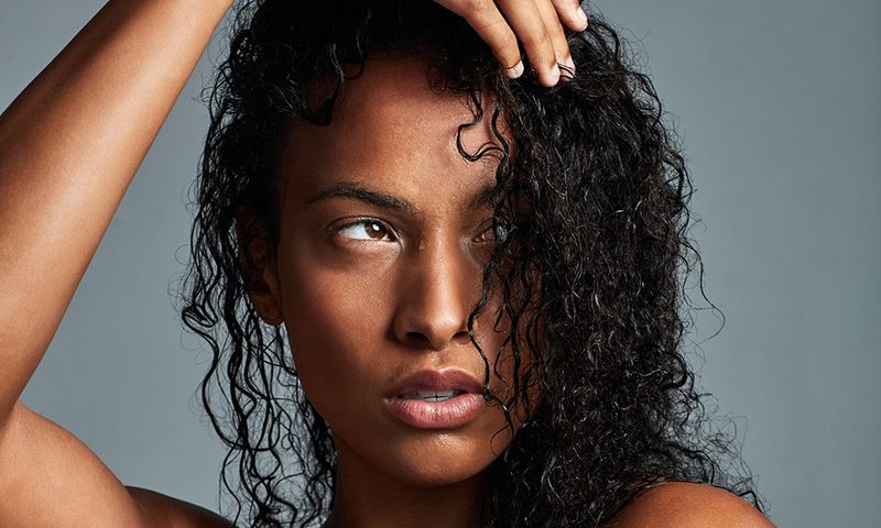 Studio shot of an attractive young woman posing against a grey background
