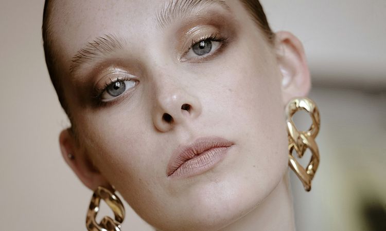 woman wearing makeup and gold earrings