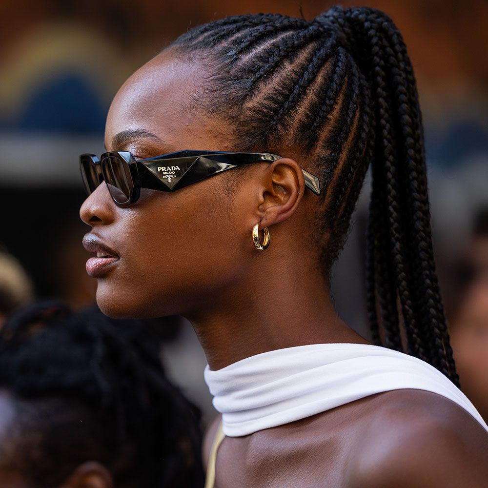 Side view of woman in sunglasses with a high cornrow braid ponytail