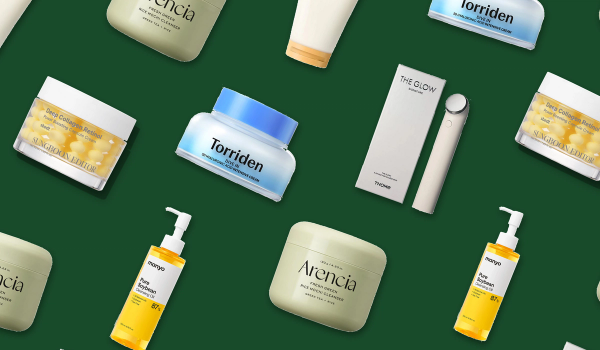 Six Korean skincare products (jars, tubes, a bottle and a beauty device) arranged in a repeating diagonal pattern on a deep green background.