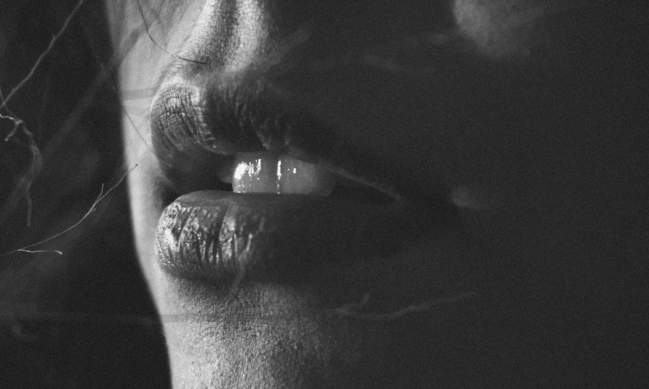 black and white image zoomed in on woman's mouth and teeth