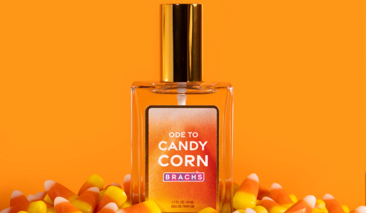 Brach’s Ode to Candy Corn eau de parfum bottle surrounded by candy corn against an orange background.