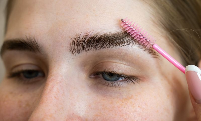 The Master Combs The Eyebrows Of The Client After Lamination Of The Eyebrows.