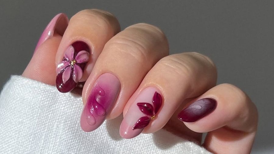 Manicure with burgundy and pink polish and floral nail art
