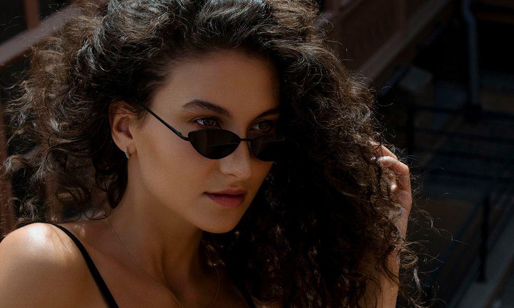 woman with curly hair wearing sunglasses