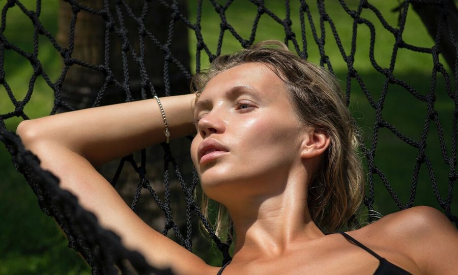 woman laying outdoors in hammock