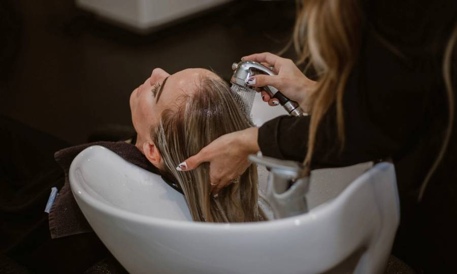 a woman having her hair rinsed at a salon