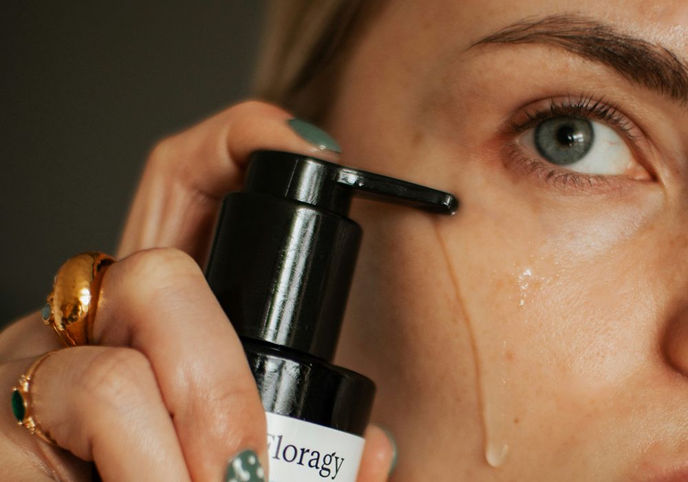 woman with skin care liquid on face