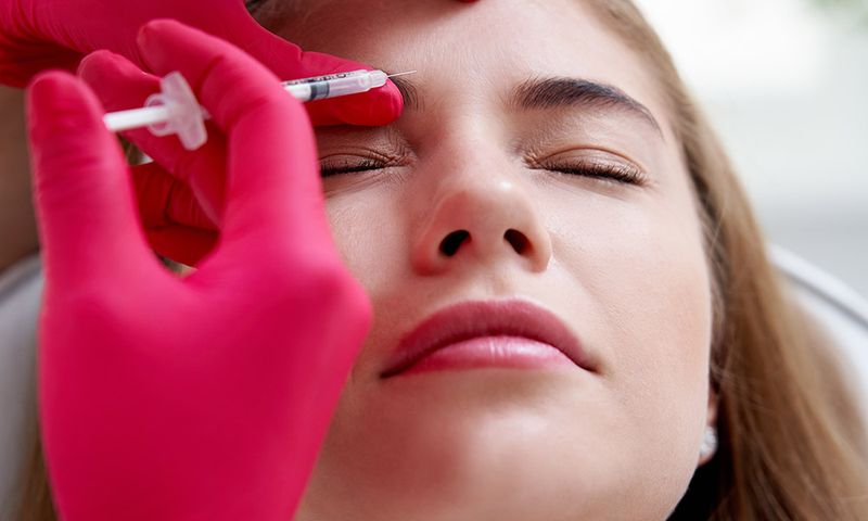 Beauty injections into a young female face. Smoothing of mimic wrinkles using biorevitalization