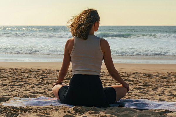 back view of woman sitting on the beach