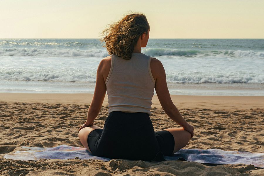 back view of woman sitting on the beach