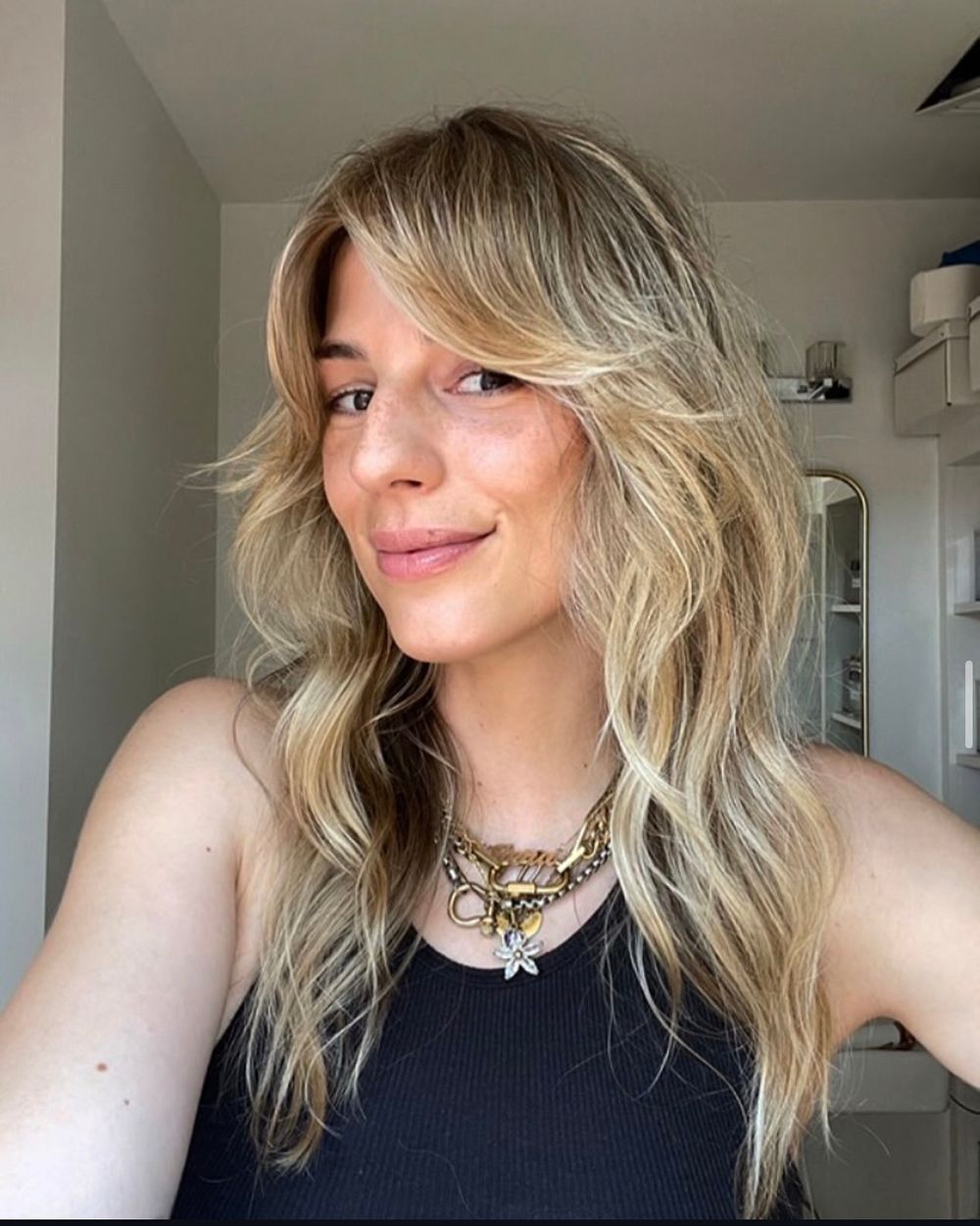 blonde woman with curtain bangs and long wavy hair