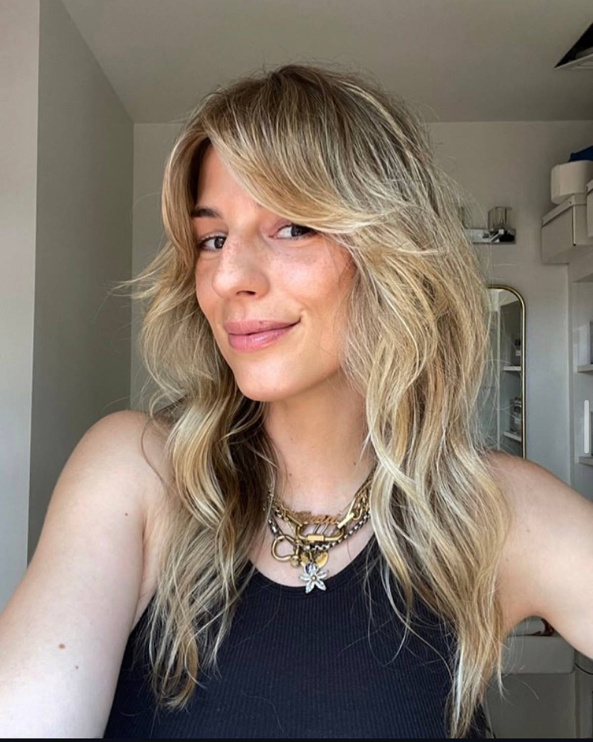 blonde woman with curtain bangs and long wavy hair