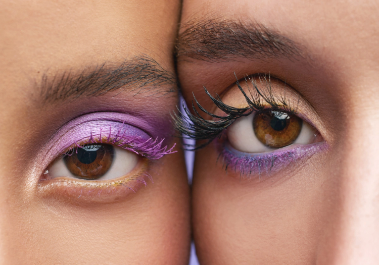Close-up of brown eyes with purple eye makeup, including lilac eye shadow, violet liner and purple mascara.