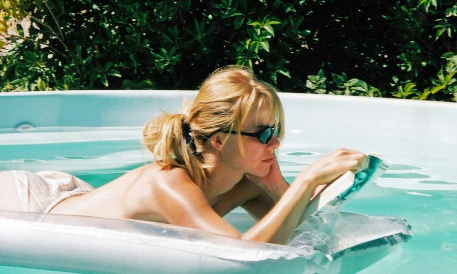 woman laying on a float and reading in a swimming pool