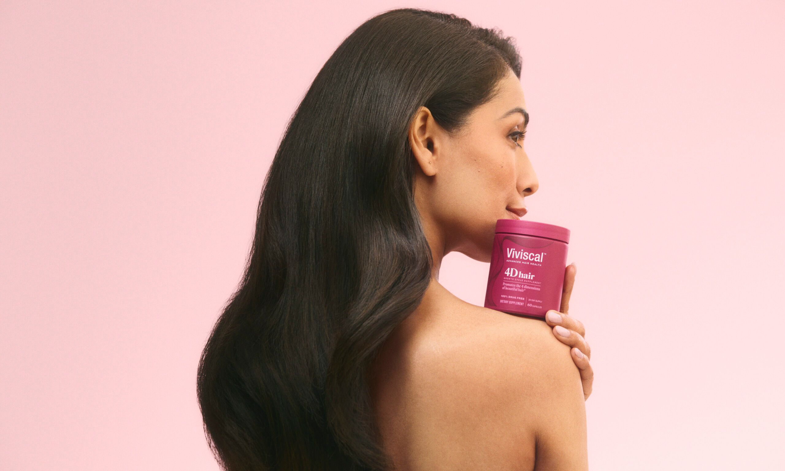 woman holding Viviscal hair supplements