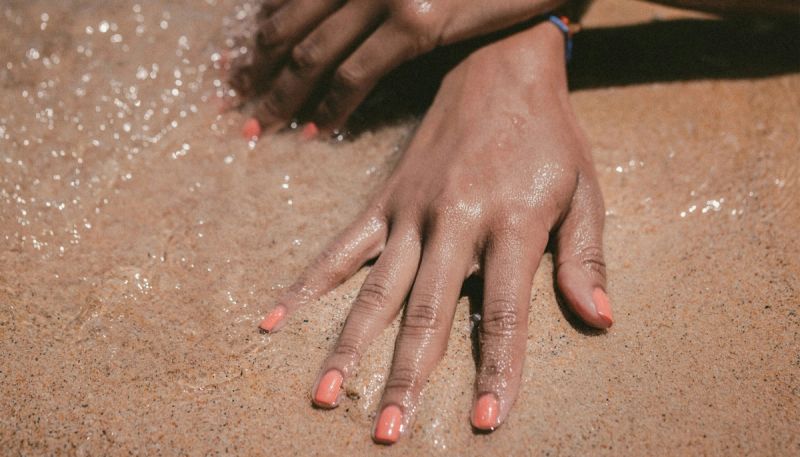 coral nails on the beach